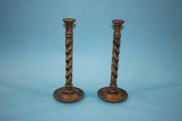 A pair of oak barley twist candlesticks