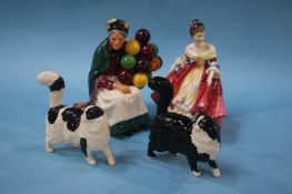 A Royal Doulton figure 'The Old Balloon Seller', a Doulton figure and two cats (4)