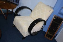 A cream Art Deco style armchair, with ebonised arms