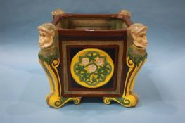 A large ceramic Majolica style jardiniere, decorated with a monkey head to each corner. 43 cm wide x