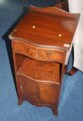 A mahogany serpentine fronted bedside cabinet