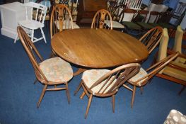 An Ercol table and set of six Ercol hoop back chairs