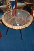 A glass top circular coffee table, with basket weave and metal framework, 68cm diameter