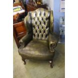 A green leather Chesterfield button back armchair