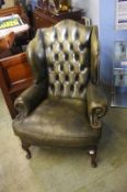 A green leather Chesterfield button back armchair