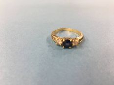 A gold coloured dress ring, mounted with blue and white sapphire