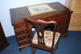 A reproduction mahogany pedestal desk and chair