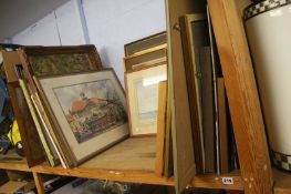 A shelf of framed watercolours, pictures and prints