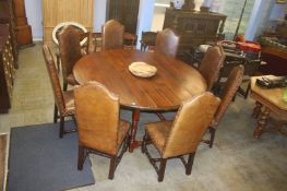 A large plank top gateleg dining table, with eight oak framed and studded chairs