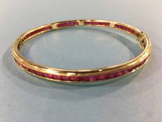 An Indian ruby mounted bangle, stamped '14', 13.4g