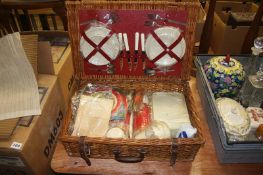 A wicker picnic basket, plus accessories