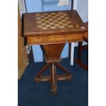 A Victorian walnut games/work table with chess board top, the top opening to reveal a green baize