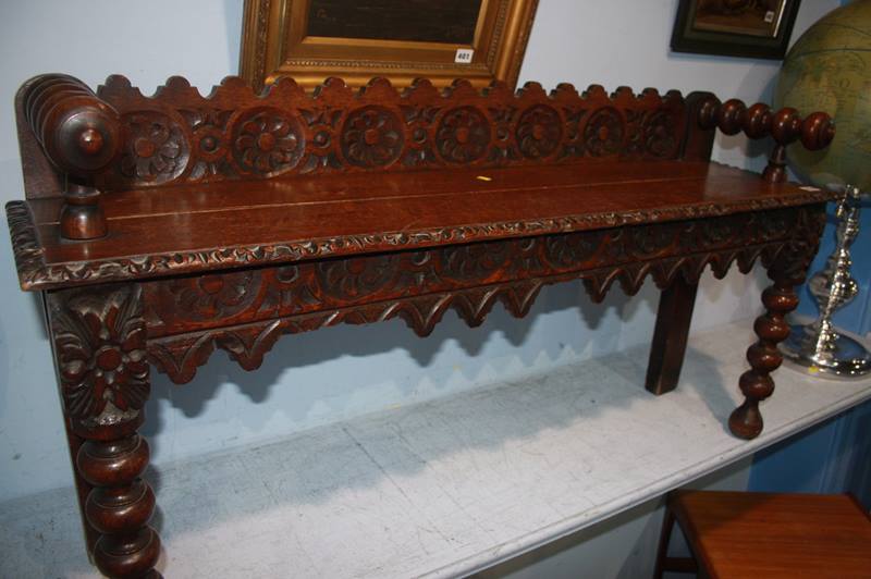 An oak carved bench, with carved frieze and bobbin turned legs, 120cm length