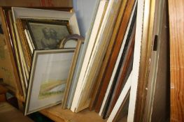 A shelf of framed paintings etc.