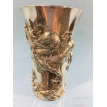 A silver plated Chinese beaker, decorated with embossed dragons