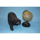 A carved Black Forest style bear and a small table globe