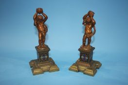 A pair of decorative brass cherubs on stands