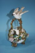 A Continental porcelain floral basket, with a bird resting on the handles