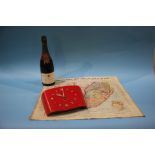 A red painted wall clock, an 'Everybody's War' map of South Africa and a bottle of champagne