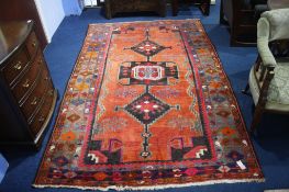 A Turkish design rug, the orange ground bearing a large triple medallion to centre, wide main border