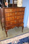 A walnut chest on stand, with two short and three long graduated drawers, supported on cabriole legs