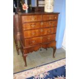 A walnut chest on stand, with two short and three long graduated drawers, supported on cabriole legs