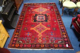 A Caucasian style rug, with triple central medallion on red ground and flower head border, 244cm x