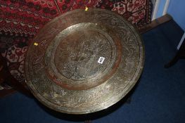 An Oriental folding engraved brass two tier table