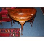 A mahogany demi lune fold over card table