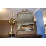 A brass oil lamp and a glass and brass fire screen