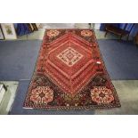 A Persian rug, with all over geometric design and central ivory pole medallion, ivory spandrels upon