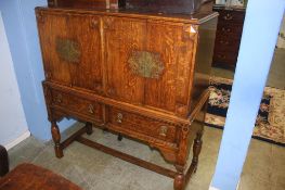 An oak four door cabinet, below two drawers, supported on turned supports, 118cm wide