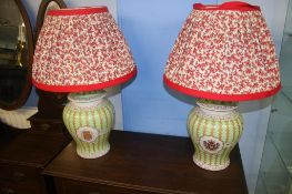 A pair of table lamps, on an apple green ground