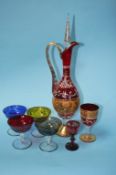 A Continental red glass decanter, decorated with gilt decoration and enamels, having six matching