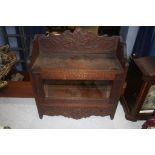 A carved wall cabinet with glazed door