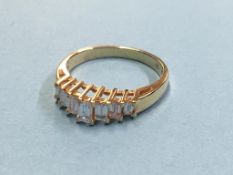 An 18ct gold diamond ring set with seven baguette cut diamonds (stamped 750)