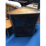 Small oak corner cabinet and a circular occasional table