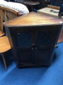 Small oak corner cabinet and a circular occasional table