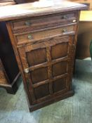 A small oak cabinet, with two drawers and panelled door below