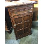 A small oak cabinet, with two drawers and panelled door below