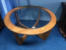 A teak circular coffee table, with inset glass top