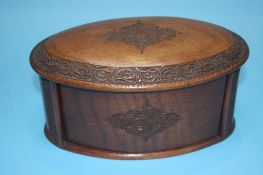 An oval shaped wooden cigarette box