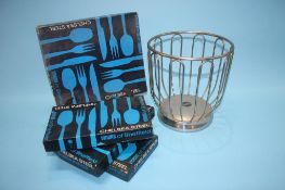 An Alessi stainless steel wine bottle holder and four boxes of Viners Chelsea steel cutlery