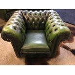 A green leather Chesterfield arm chair