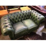 A green leather Chesterfield two seater settee