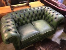 A green leather Chesterfield two seater settee