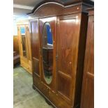 An Edwardian mahogany mirror door wardrobe