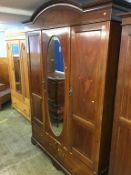 An Edwardian mahogany mirror door wardrobe