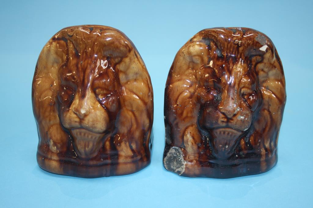 A pair of 19th century treacle glazed pottery Sash window rests, formed as Lion heads (2)