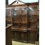 A good reproduction breakfront four door bookcase with central pull out slide, with leather gilt